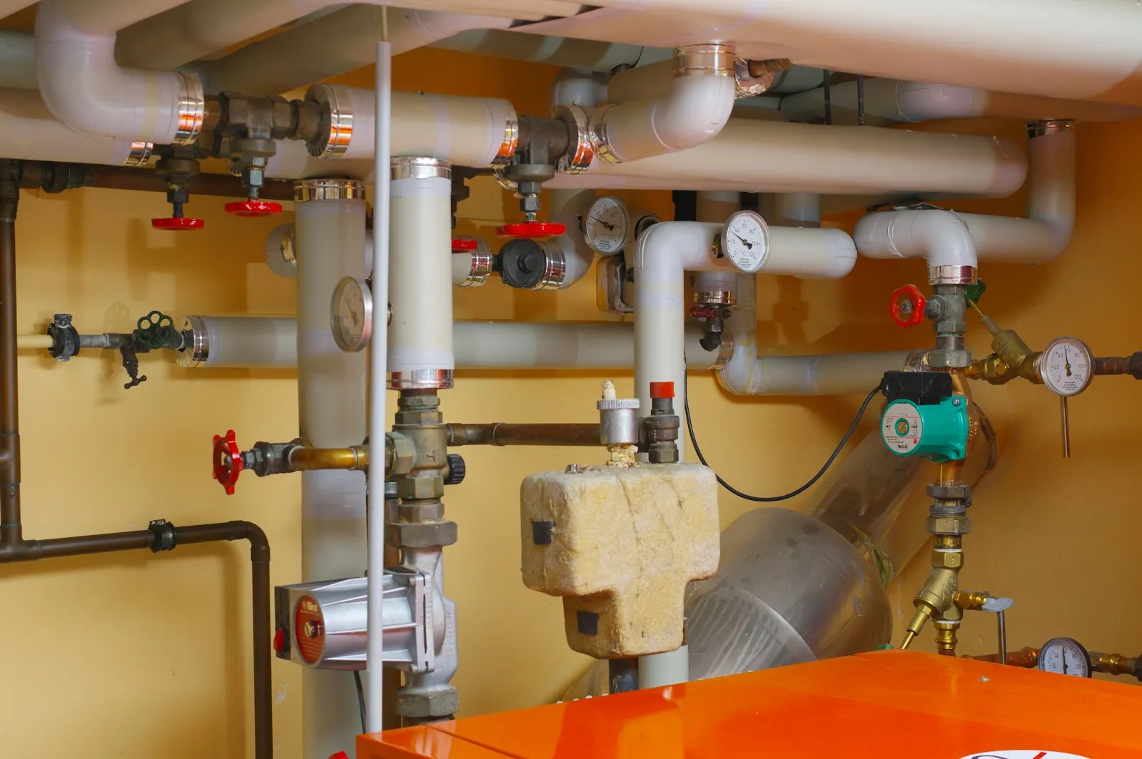 Tuyaux, vannes et circulateur d'une installation de chauffage dans une chaufferie