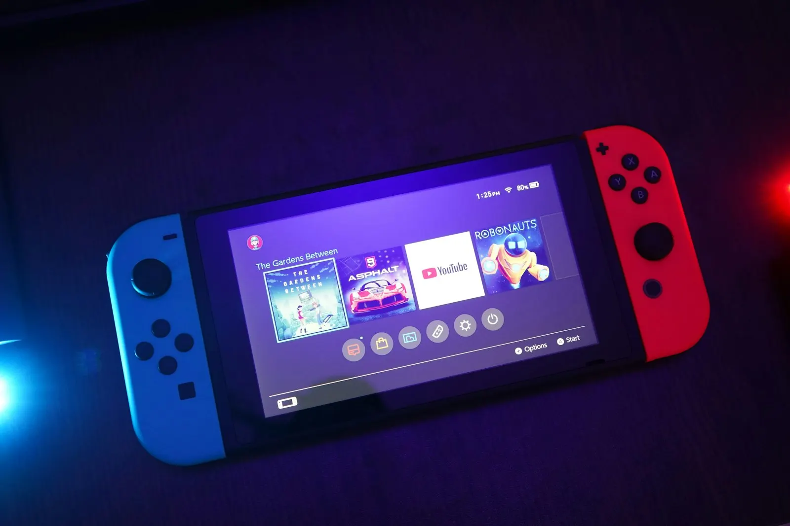 Console Nintendo Switch avec ses Joy-Con bleu et rouge, écran allumé