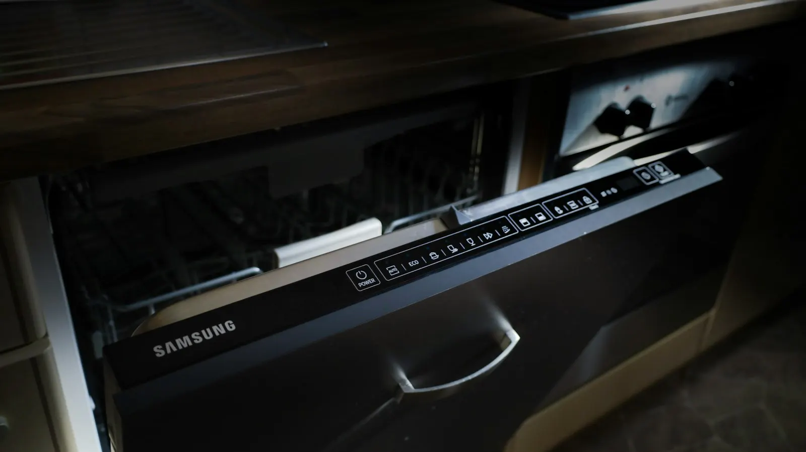 Lave-vaisselle Samsung encastré, porte entrouverte sous un plan de travail