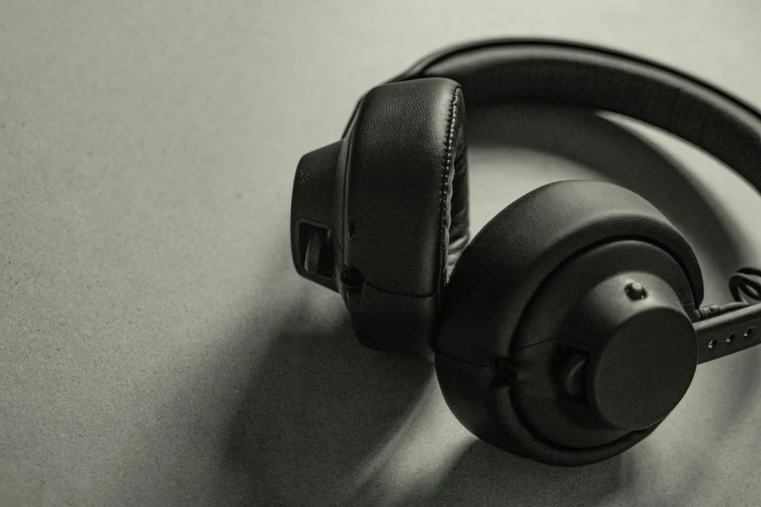 Casque circum-aural noir posé sur une surface gris clair, arceau replié