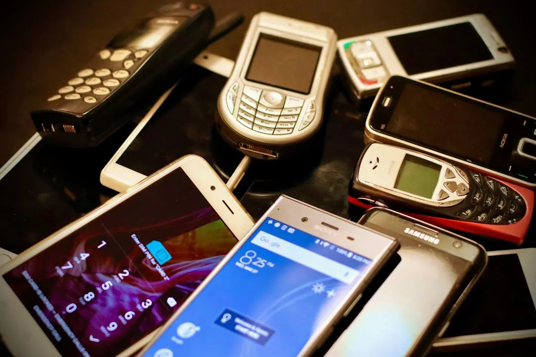 Plusieurs téléphones portables de marques différentes, Android et Nokia, posés côte à côte sur une table