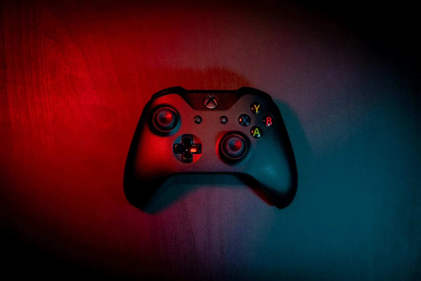 Manette Xbox noire sur un fond éclairé en rouge et bleu
