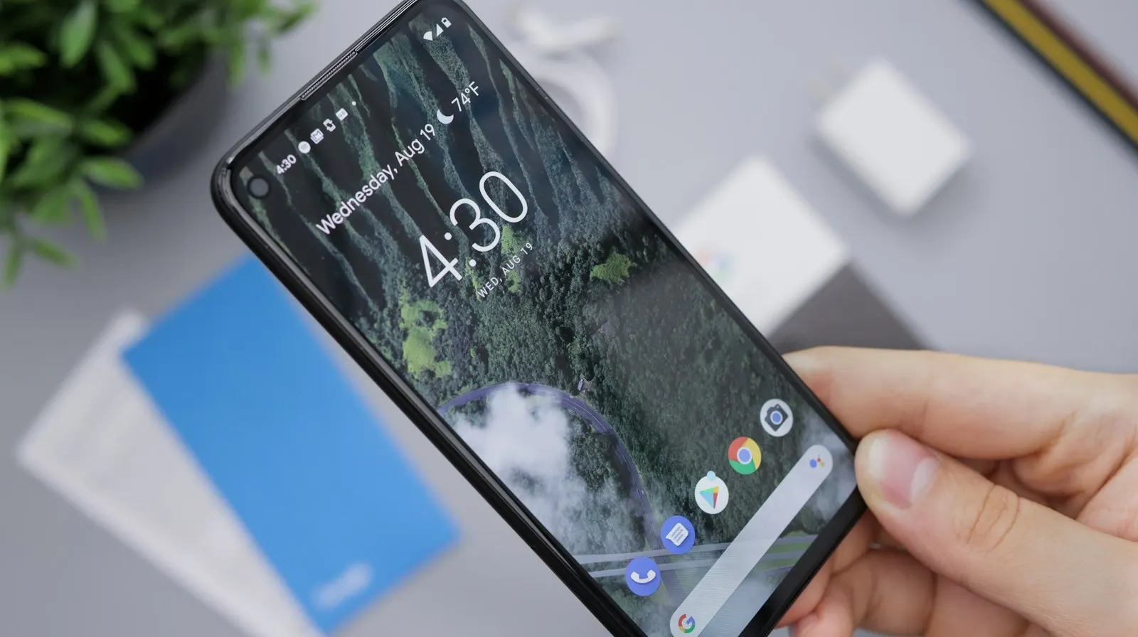 Main qui tient un smartphone Android noir allumé