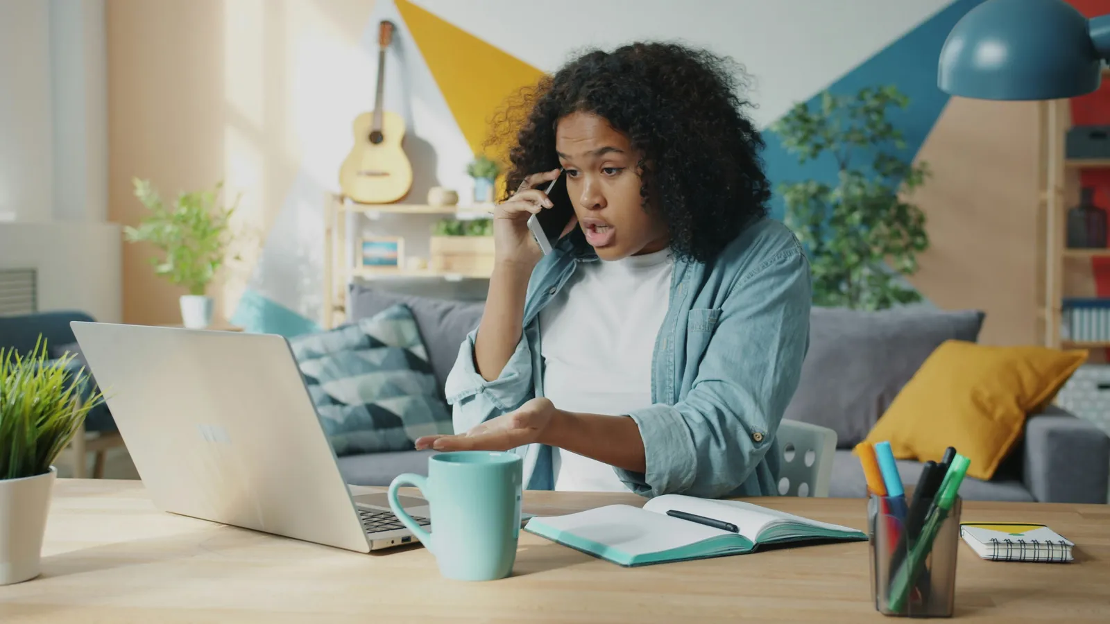 Femme excédée au téléphone devant son ordinateur portable, en train de se plaindre auprès d'un service client